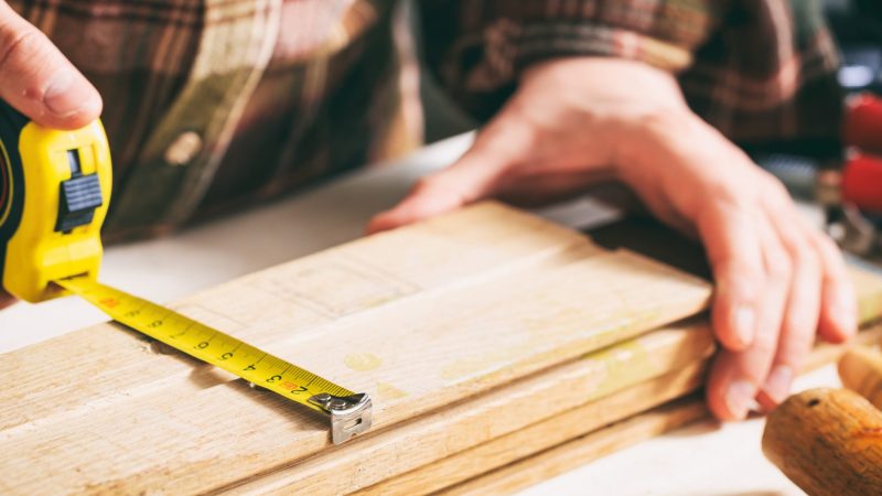 carpenter-holding-a-measure-tape-P7ATBZ6-scaled